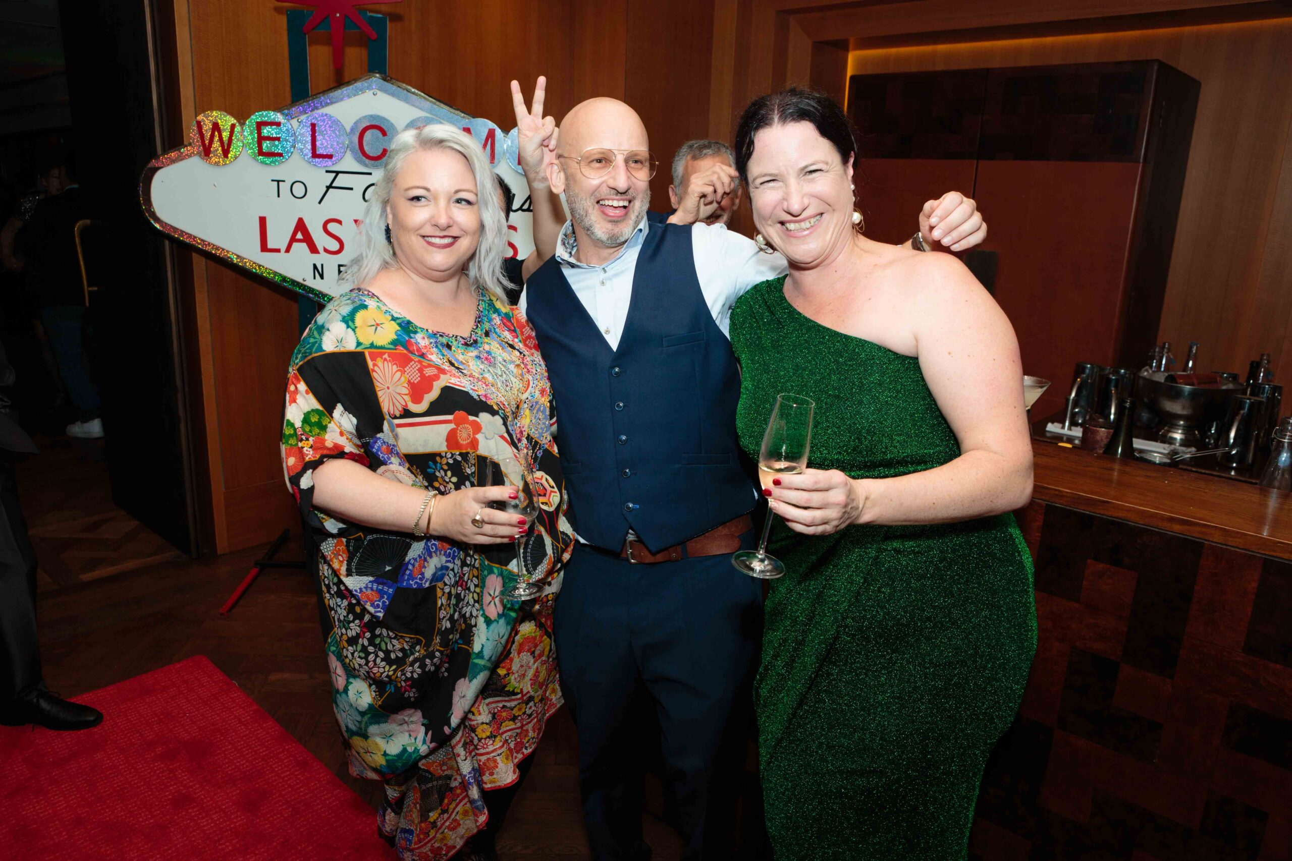 three coworkers posed together at work Christmas party